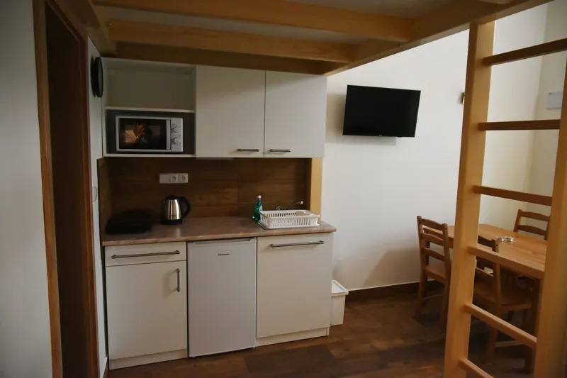 Kuchyňka a dřevěné patro v přízemním apartmánu