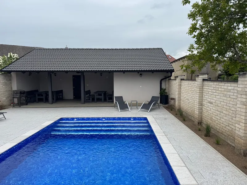 Vyhřívaný bazén v zahradě s lehátky