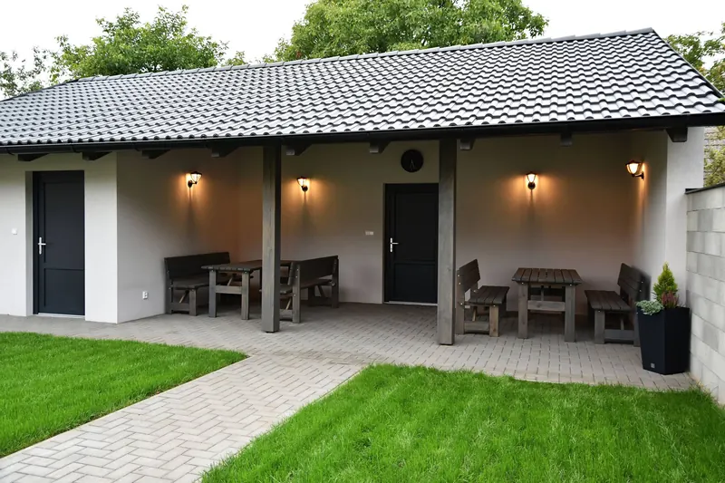 Zahrada s krytým posezením a vstupy do apartmánů